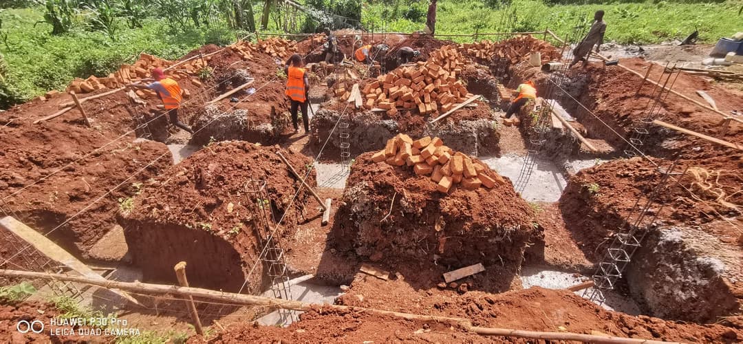 Workers in safety gear laying foundation footings and reinforcement